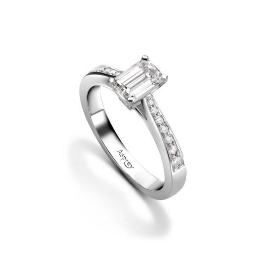 Обручальное кольцо от Asprey с алмазом в форме «подушечки» и круглыми блестящими бриллиантами на платиновой полосе.